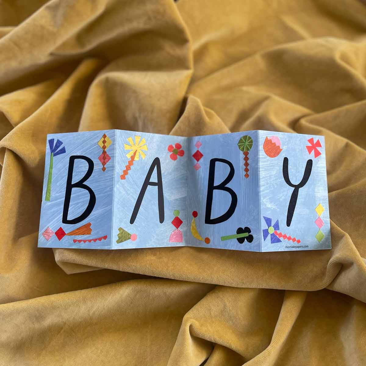 Beautifully designed Baby Concertina Greeting Card, fully opened to reveal its vibrant hand-painted artwork, displayed on a bright yellow background. Printed on eco-friendly recycled paper