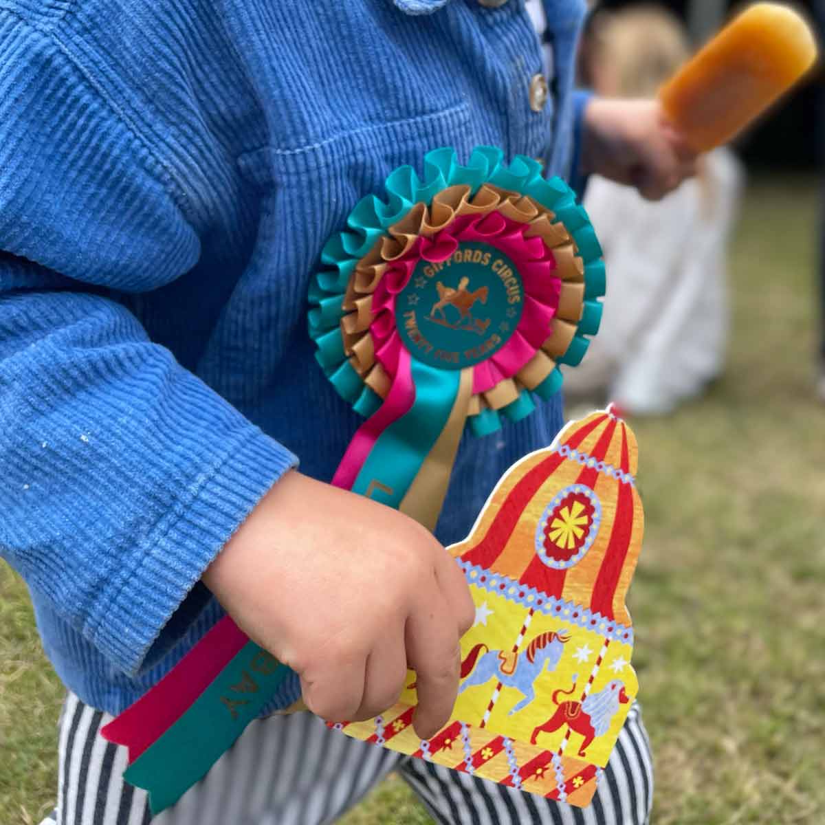 Child holding Carousel shapes greetings card and playing