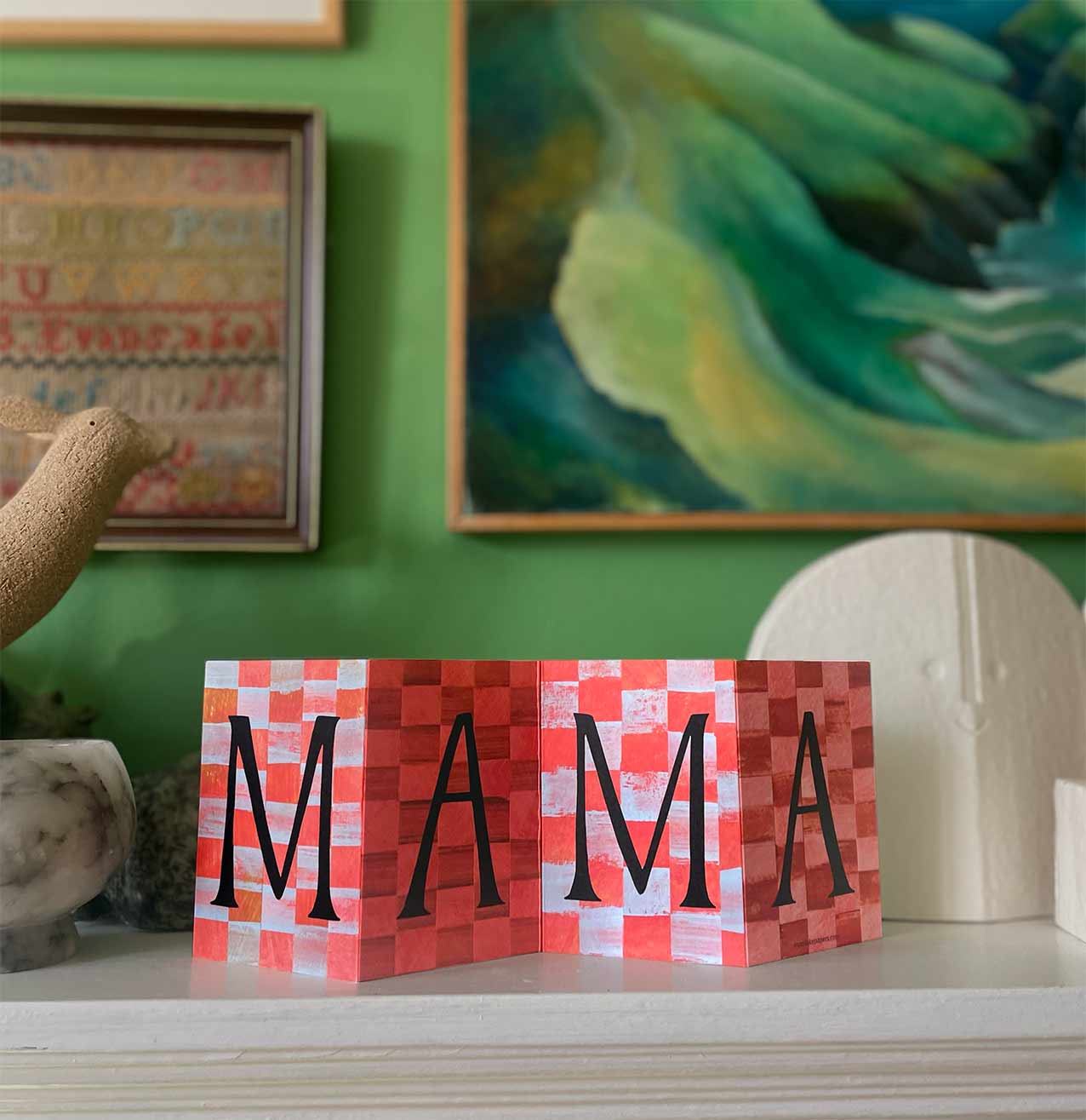 Mama Concertina Card for Mothers Day displayed on a mantlepiece with a green background opened to reveal its full artwork.