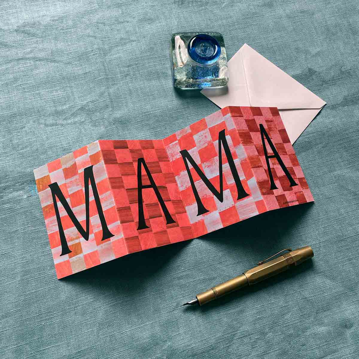Beautifully designed Mama Concertina Card, opened to reveal its full artwork displayed on a blue background with a fountain pen
