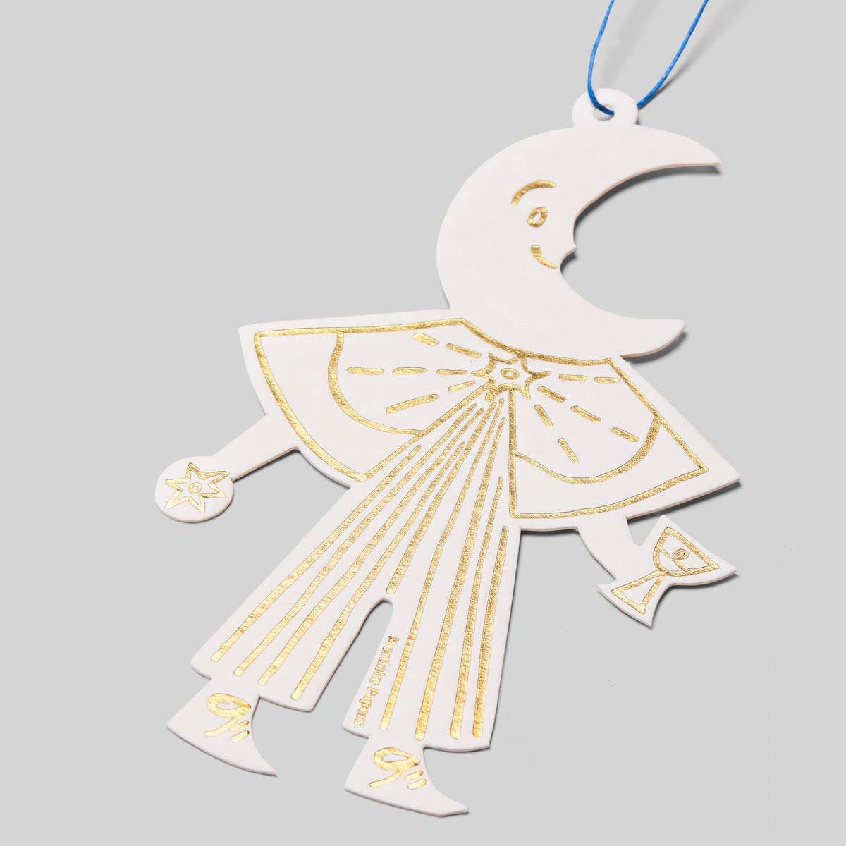 Decorative cutout ornament of a moon folk figure on a gray background