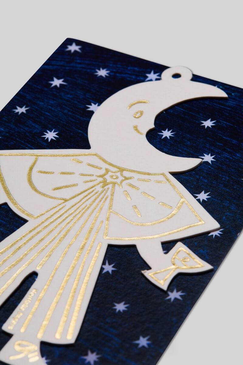 White and gold letterpress Moon Folk Ornament with starry blue packaging