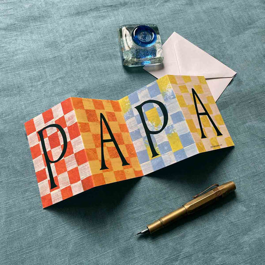 Close-up of the Papa Concertina Card, featuring joyful patterns on a bkue background with a fountain pen
