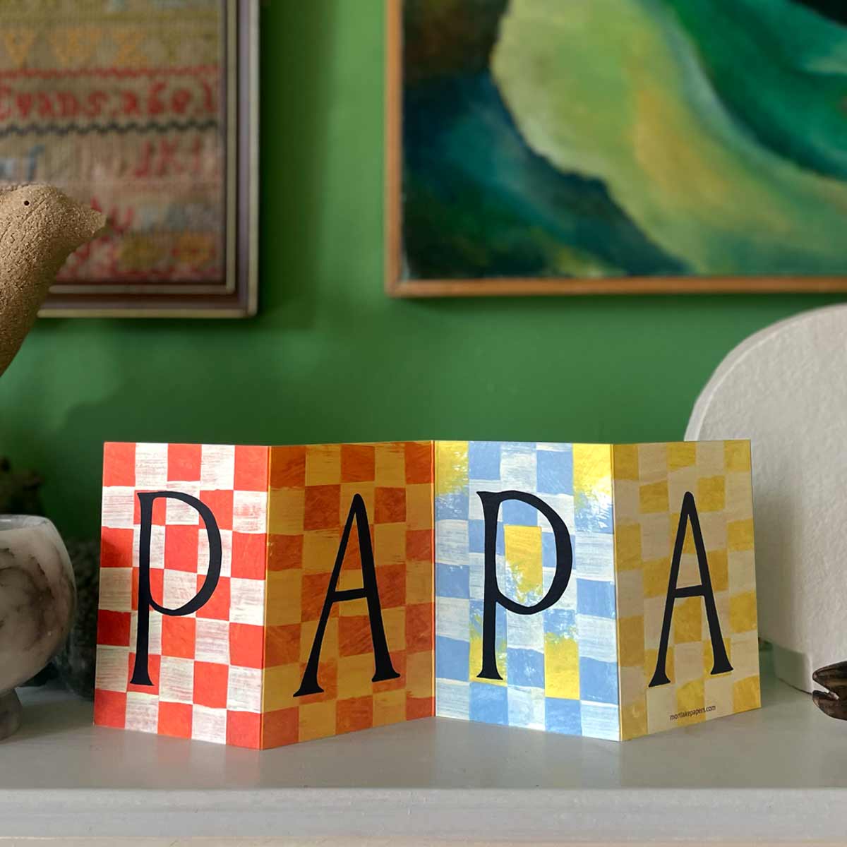 Papa Concertina Card displayed on a mantlepiece with a green background opened to reveal its full artwork