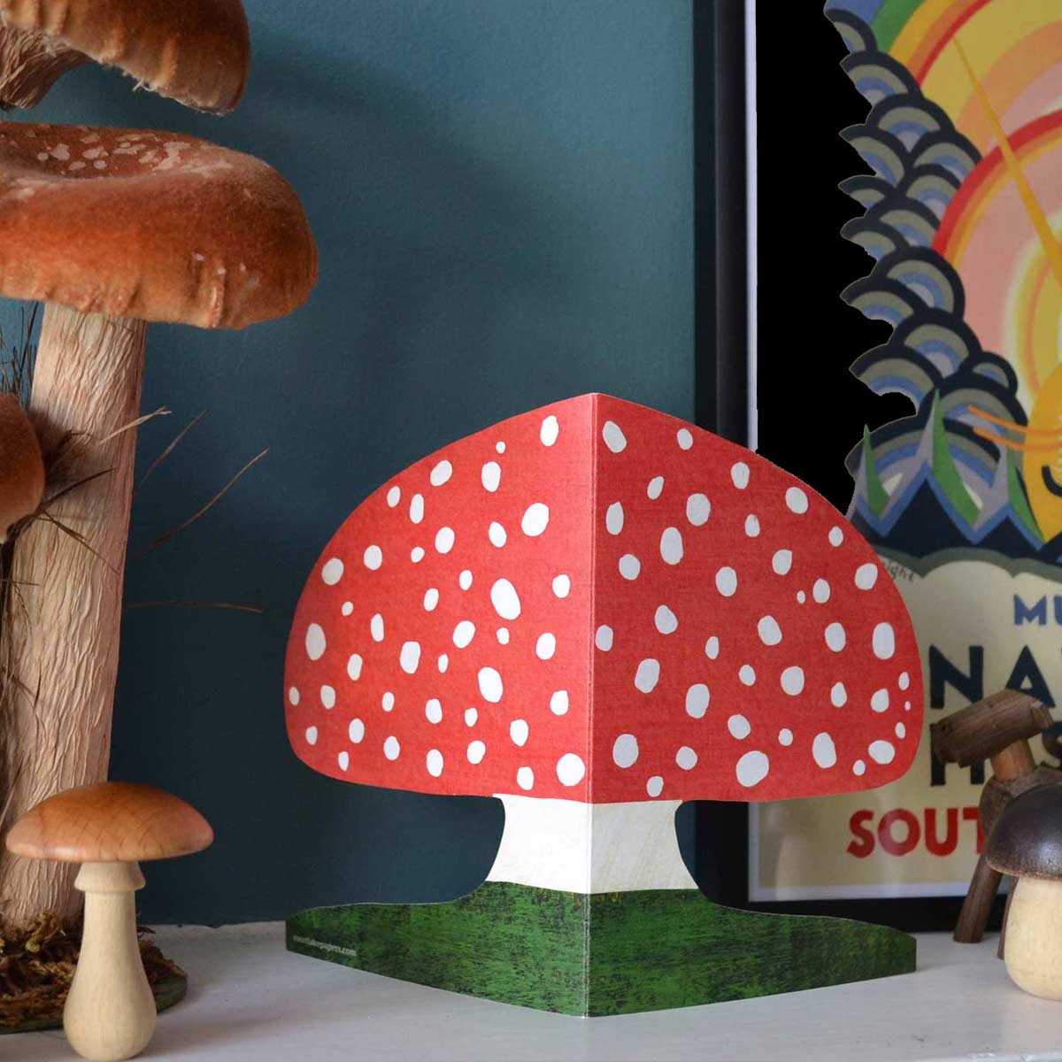 Red  Mushroom die cut greeting card on a shelf with mushrooms