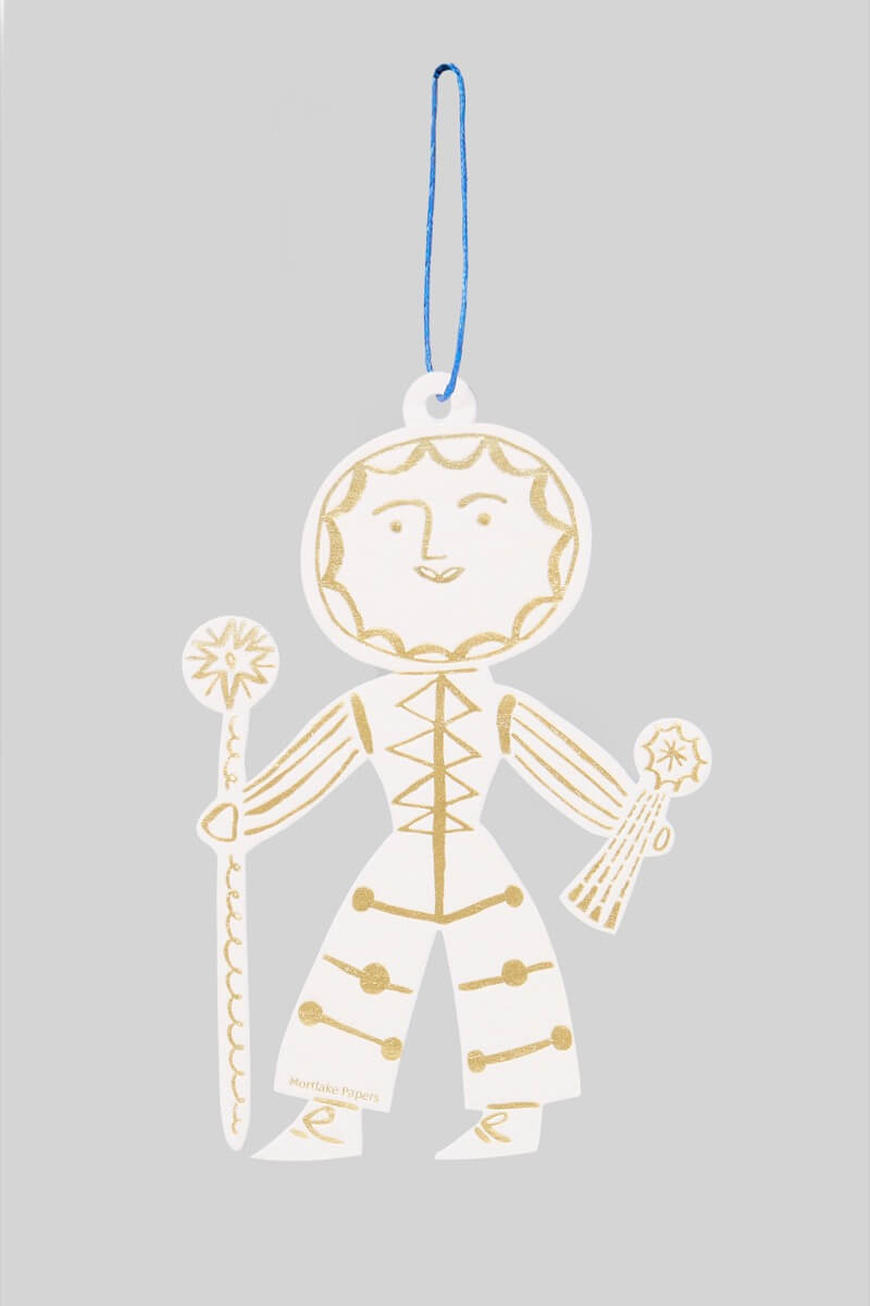 Decorative Sun Folk ornament in gold and white on a gray background