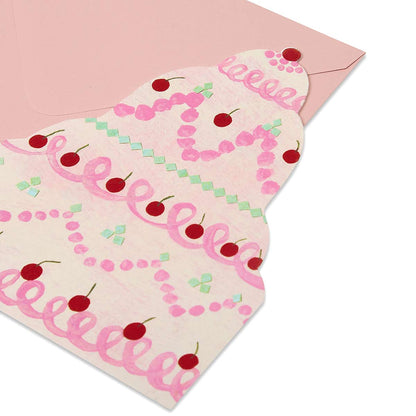 Die cut tiered cake greetings card with pink looped icing red cherries on a blush pink envelope.
