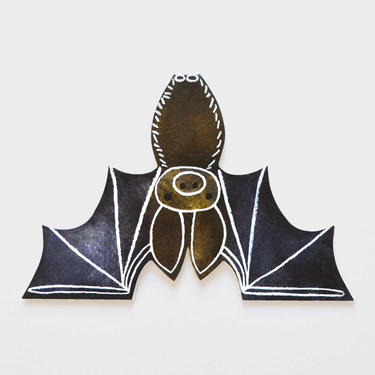 Eco friendly cut out bat card standing upside down against an off white background