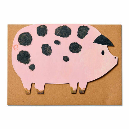 Pink spotty pig die cut greetings card on top of kraft brown recycled envelope